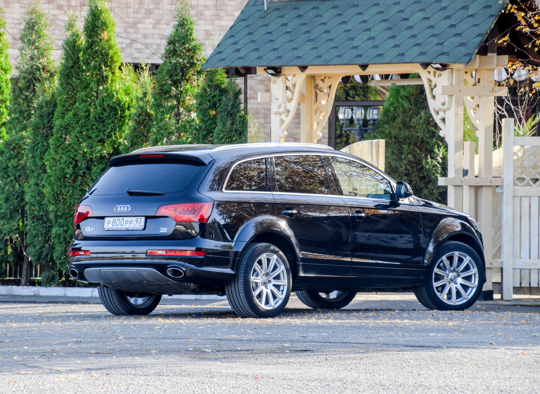 Car Black Audi Q7 in the Parking Lot near the Fence. City Crossover from Audi.